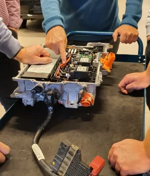 Detaljert bilde av biltekniker som jobber med elektrisk bilbatteri.