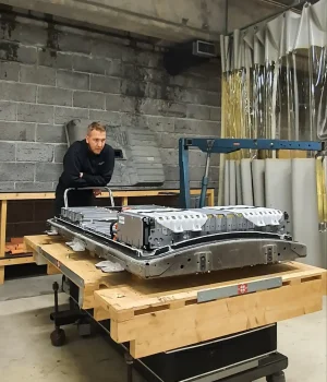 Bilde av tekniker som jobber på elbilbatteri på verksted.