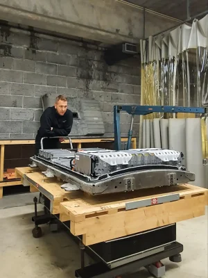 Bilde av tekniker som jobber på elbilbatteri på verksted.