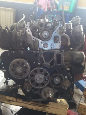 Robusten autoverksted med bilmotor i arbeid.