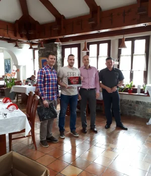 Åsane Autoservice-team mottar pris under en feiring i lokalet.