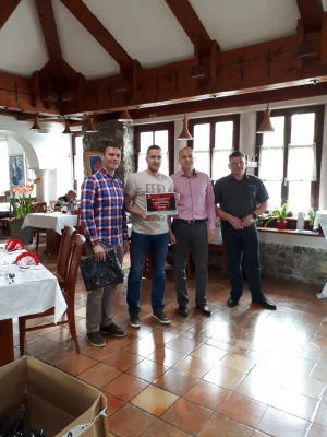 Åsane Autoservice-team mottar pris under en feiring i lokalet.